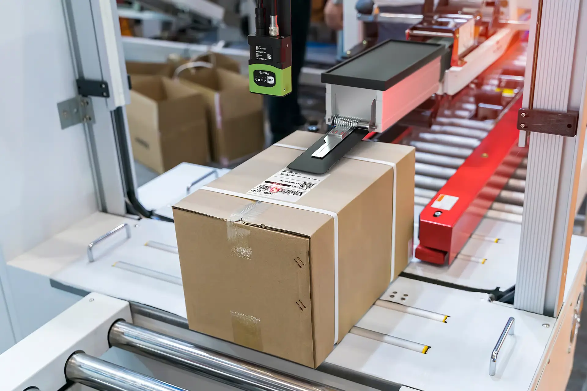 Băng chuyền tự động dán tem mã vạch lên các thùng carton trong quy trình đóng gói sản phẩm